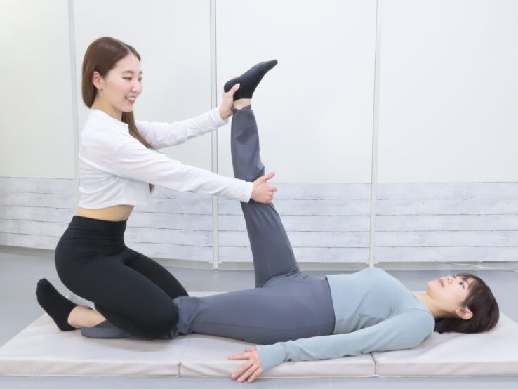 高田馬場・目白・下落合エリアのパーソナルジム『パーソナルランド』で、女性トレーナーがマンツーマンでストレッチ指導を行っている様子。柔軟性向上や身体のケアにも対応しており、初心者や運動に不安のある方にも最適。